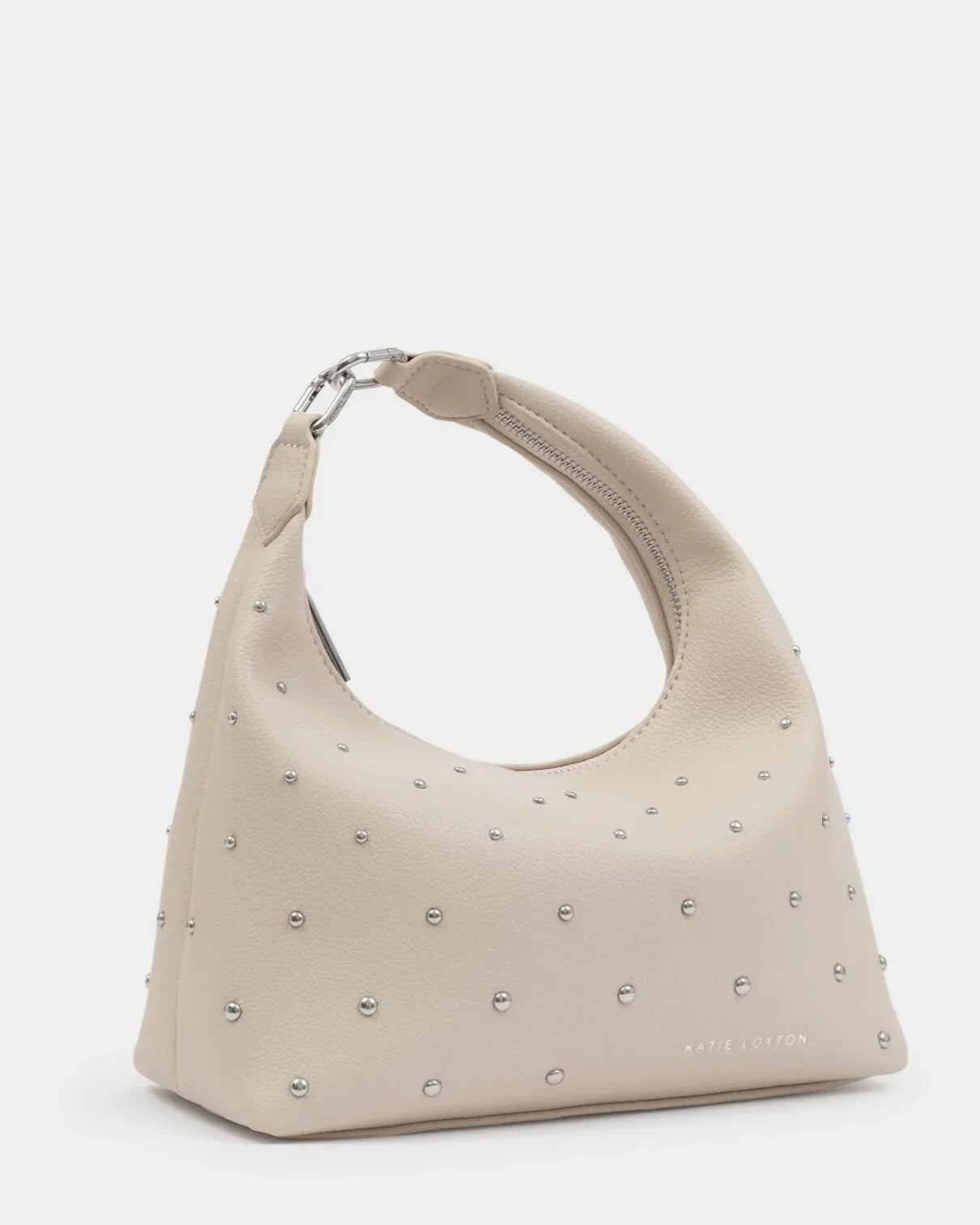 Beige handbag with studded details on a light gray background