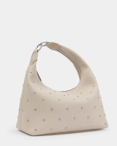 Beige handbag with studded details on a light gray background